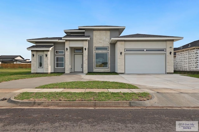 119 Finch Dr, Los Fresnos, TX 78566 - prairie-style house featuring fence, an attached garage, driveway, and stone siding