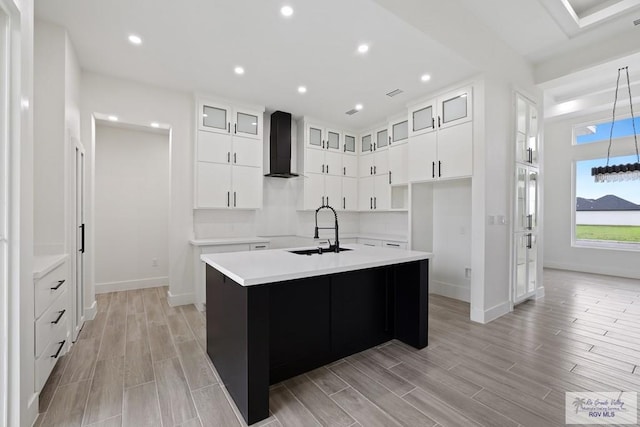 119 Finch Dr, Los Fresnos, TX 78566 - kitchen with wall chimney range hood, baseboards, an island with sink, and a sink