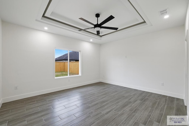 119 Finch Dr, Los Fresnos, TX 78566 - spare room featuring dark wood-style flooring, ceiling fan, a raised ceiling, recessed lighting, and visible vents