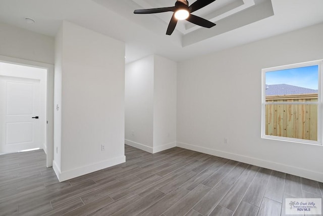 119 Finch Dr, Los Fresnos, TX 78566 - empty room with a tray ceiling, baseboards, a ceiling fan, and wood finished floors