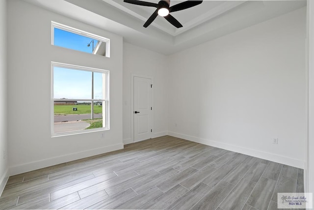 119 Finch Dr, Los Fresnos, TX 78566 - spare room with plenty of natural light, a ceiling fan, a tray ceiling, and light wood finished floors