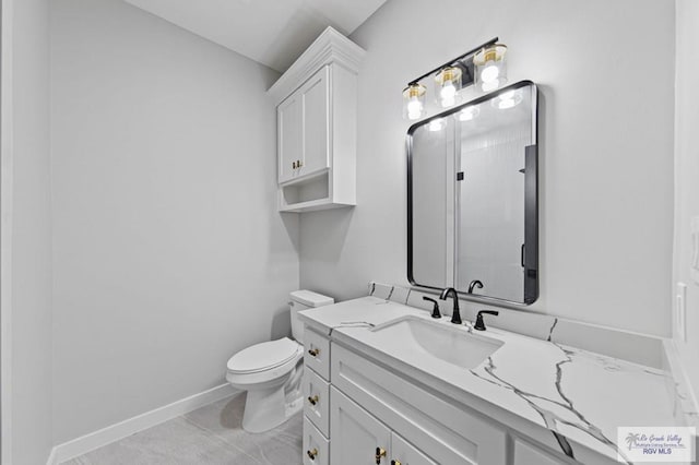 bathroom featuring tile patterned flooring, vanity, and toilet