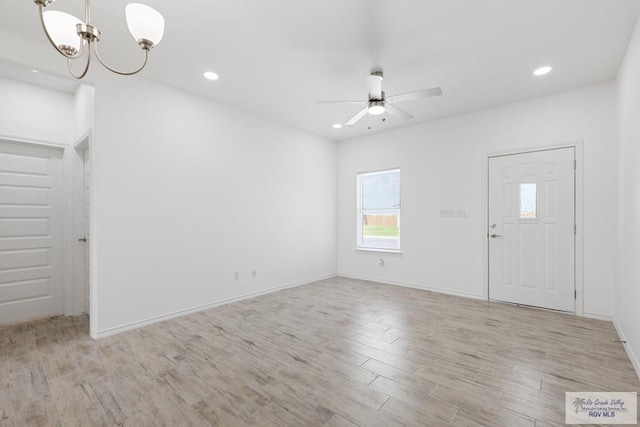 foyer entrance featuring light hardwood / wood-style flooring and ceiling fan with notable chandelier