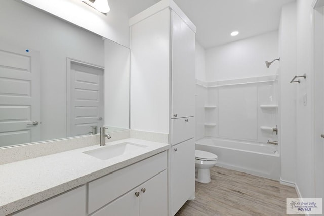 full bathroom with hardwood / wood-style floors, vanity, toilet, and tub / shower combination