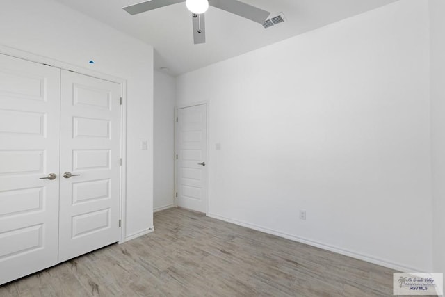 unfurnished bedroom featuring ceiling fan, a closet, and light wood-type flooring