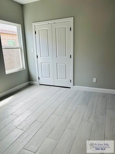 521 Valley Oak Cir, Los Fresnos, TX 78566 - unfurnished bedroom with wood finished floors, baseboards, and a closet