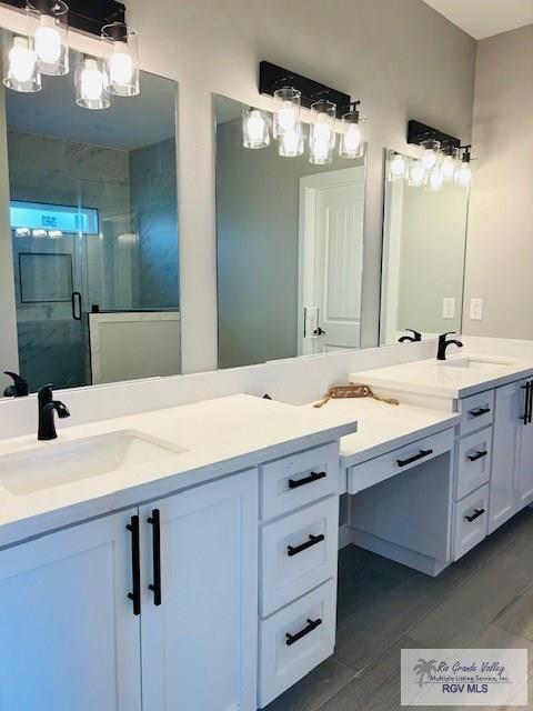 521 Valley Oak Cir, Los Fresnos, TX 78566 - full bath with double vanity, a shower stall, and wood finished floors