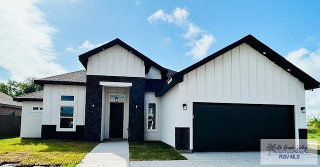 521 Valley Oak Cir, Los Fresnos, TX 78566 - view of front facade with board and batten siding, a garage, and driveway