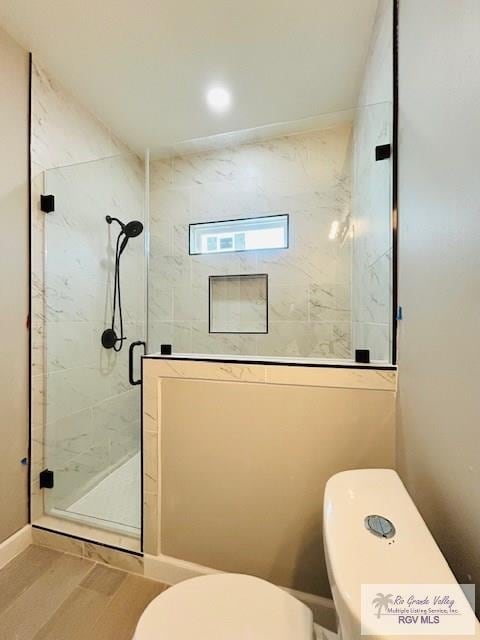 521 Valley Oak Cir, Los Fresnos, TX 78566 - bathroom featuring toilet, a stall shower, and wood finished floors