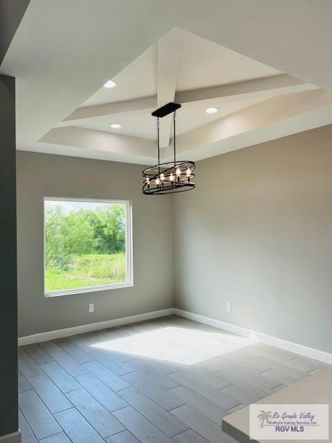 521 Valley Oak Cir, Los Fresnos, TX 78566 - empty room with baseboards, wood finished floors, a tray ceiling, recessed lighting, and a chandelier