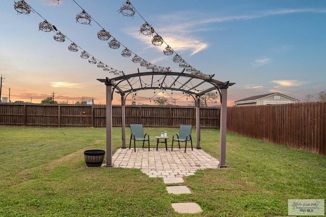 yard at dusk featuring a pergola and a patio area