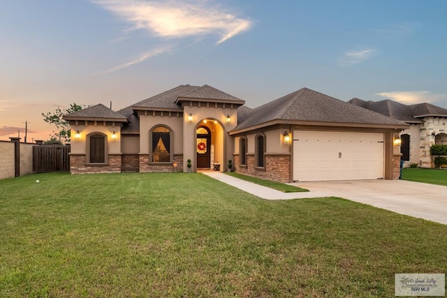 view of front of property with a yard and a garage