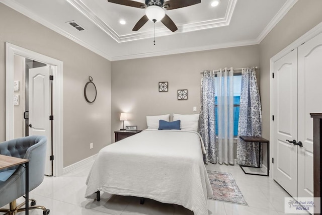 bedroom with ornamental molding, light tile patterned floors, ceiling fan, and a tray ceiling