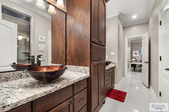 bathroom with crown molding, vanity, and tile patterned flooring