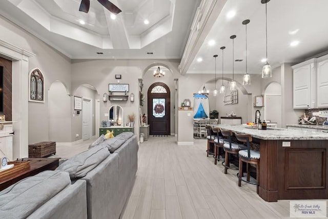 living room featuring ornamental molding, sink, ceiling fan, and light hardwood / wood-style floors