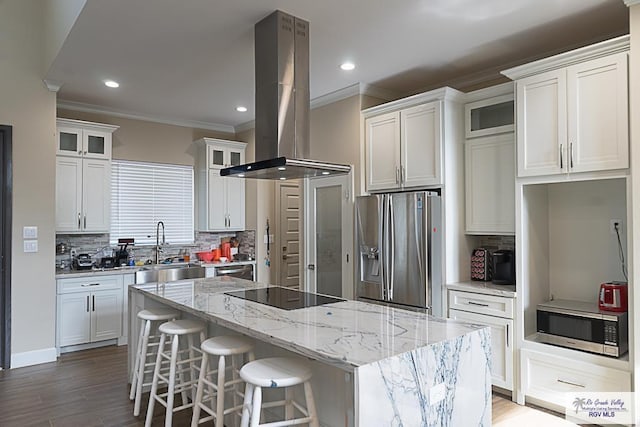 kitchen featuring crown molding, a kitchen island, island exhaust hood, stainless steel appliances, and white cabinets