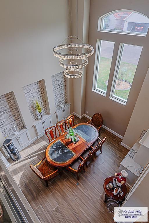 dining area featuring dark hardwood / wood-style flooring and a high ceiling