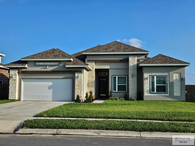 prairie-style house featuring a front yard and a garage