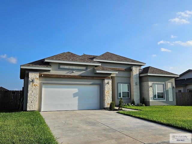 prairie-style house featuring a garage and a front lawn