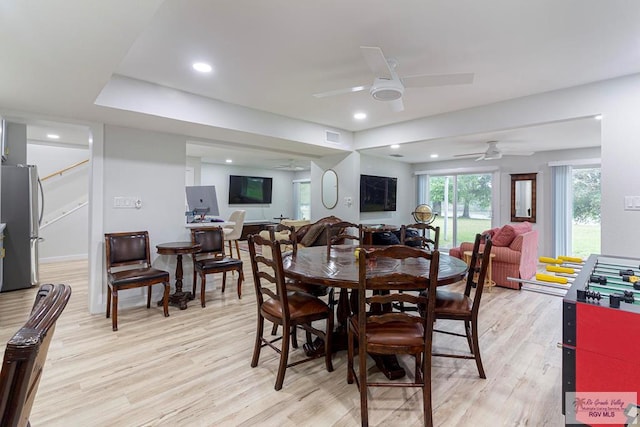 dining area with light wood-type flooring and ceiling fan