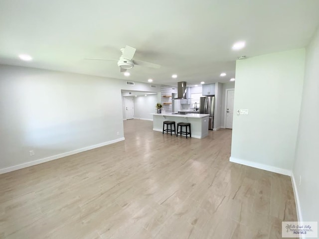 living area featuring baseboards, ceiling fan, light wood-type flooring, and recessed lighting