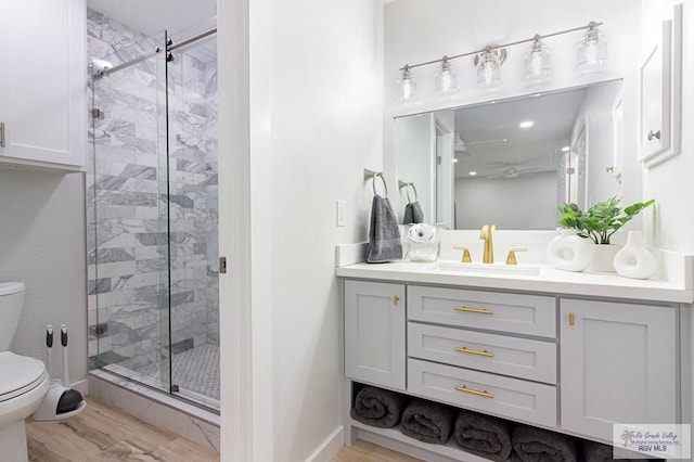 bathroom featuring hardwood / wood-style flooring, vanity, toilet, and walk in shower