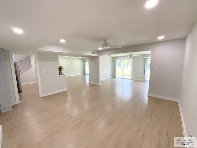 spare room with baseboards, a ceiling fan, and light wood finished floors
