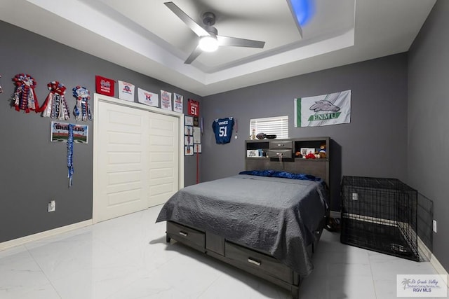 9129 Lake Charles Dr, Los Fresnos, TX 78566 - bedroom featuring a raised ceiling, light marble finish flooring, ceiling fan, and a closet
