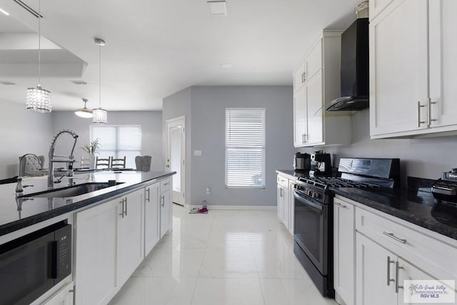 9129 Lake Charles Dr, Los Fresnos, TX 78566 - kitchen featuring black gas range oven, wall chimney exhaust hood, pendant lighting, and white cabinets