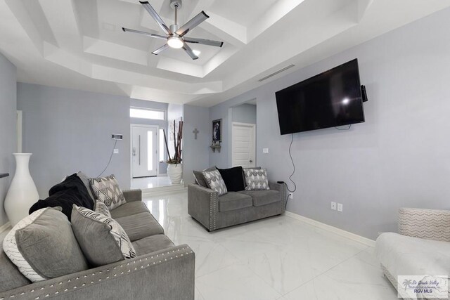9129 Lake Charles Dr, Los Fresnos, TX 78566 - living area featuring a ceiling fan, a tray ceiling, and marble finish flooring
