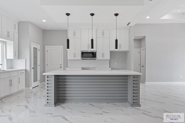 kitchen featuring pendant lighting, a center island, and white cabinets