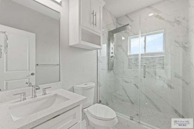 bathroom featuring vanity, toilet, and an enclosed shower