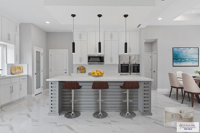 kitchen with hanging light fixtures, an island with sink, white cabinets, and refrigerator