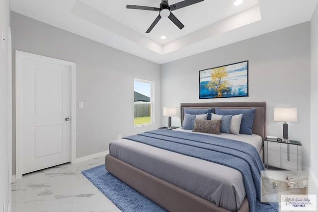 bedroom with a raised ceiling and ceiling fan