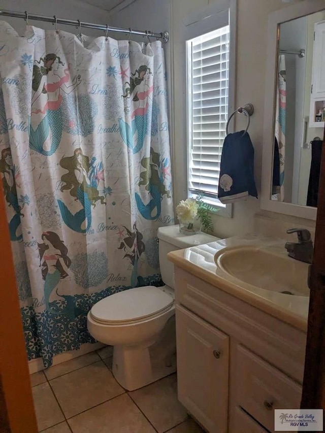 bathroom with tile patterned flooring, vanity, and toilet