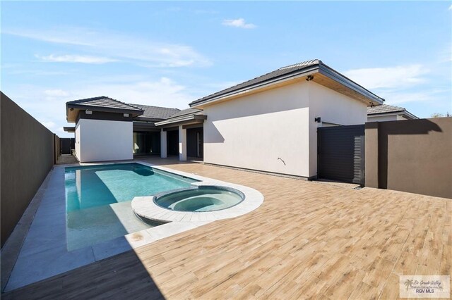 view of swimming pool with an in ground hot tub and a wooden deck