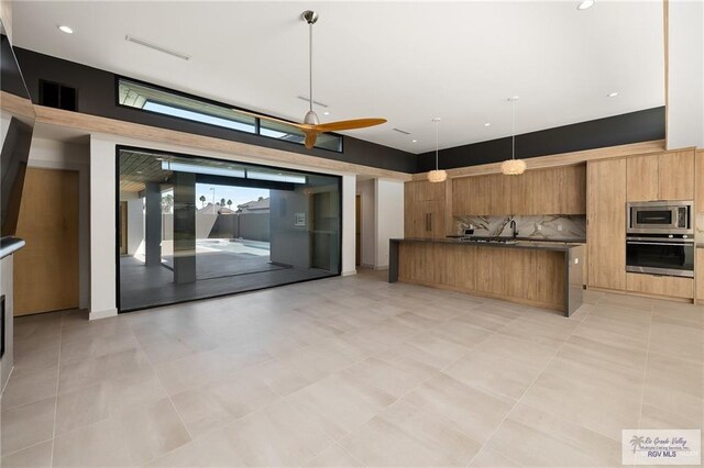 kitchen featuring decorative backsplash, decorative light fixtures, and stainless steel appliances