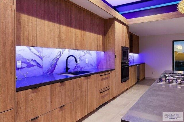 kitchen with decorative backsplash, sink, light tile patterned floors, and stainless steel appliances