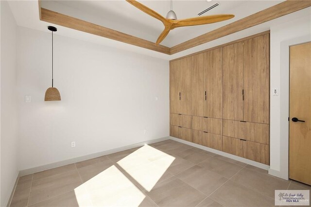 spare room with light tile patterned floors, a raised ceiling, and ceiling fan