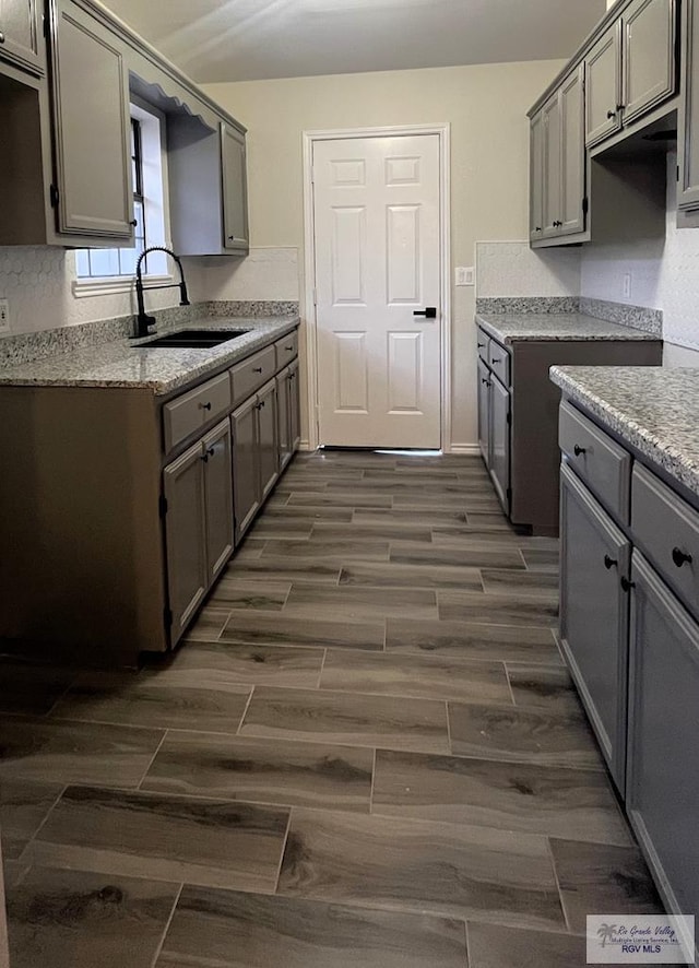 kitchen featuring gray cabinets, dark wood-type flooring, and sink