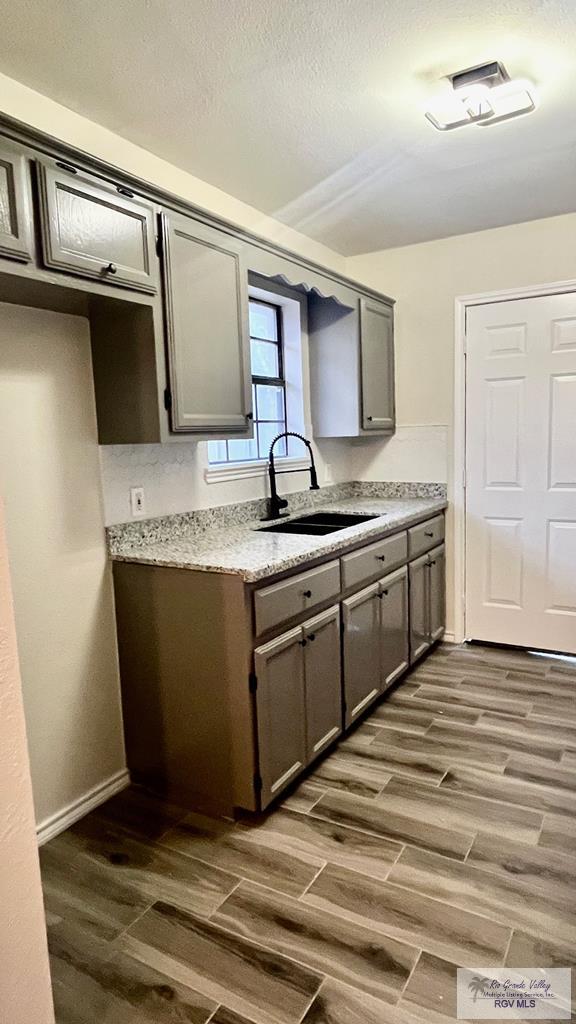 kitchen featuring gray cabinets, dark hardwood / wood-style flooring, and sink