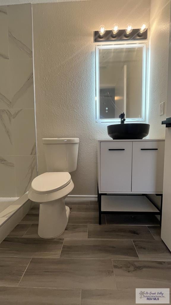 bathroom featuring hardwood / wood-style flooring, vanity, and walk in shower