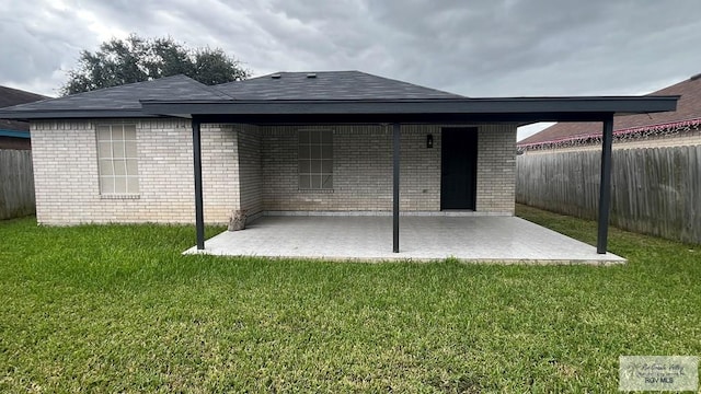 rear view of property with a lawn and a patio