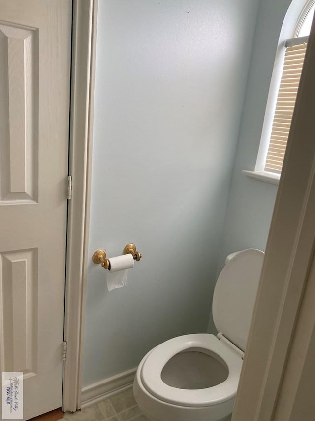 bathroom with baseboards and toilet