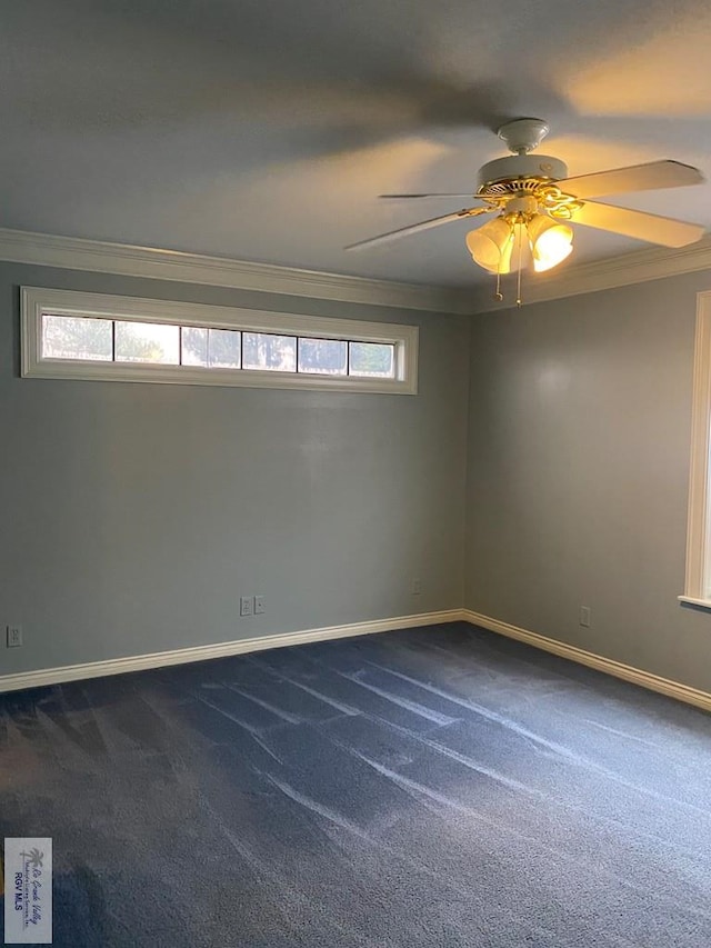 spare room with dark colored carpet, baseboards, ceiling fan, and crown molding