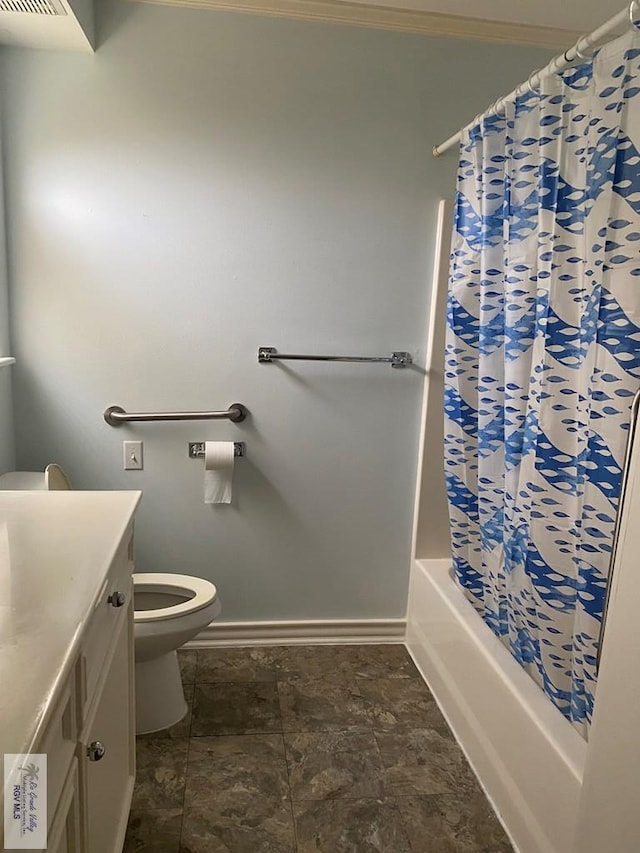 bathroom with vanity, toilet, shower / bath combo, and baseboards