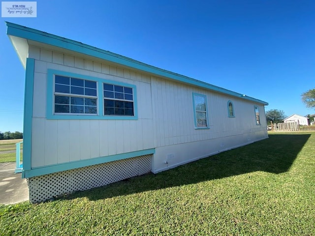 view of side of home with a lawn and crawl space