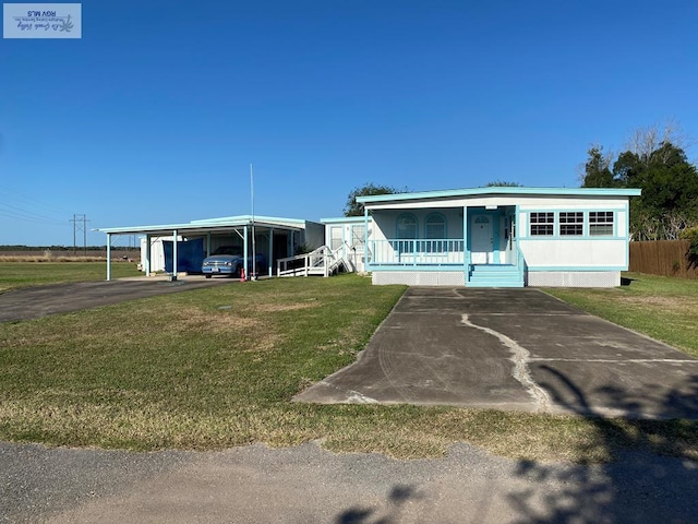 manufactured / mobile home with a detached carport, a porch, and a front lawn