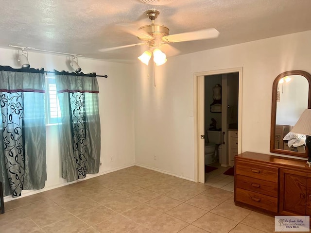 501 W Palm Valley Dr, Harlingen, TX 78552 - bedroom with ceiling fan, a textured ceiling, connected bathroom, and light tile patterned floors