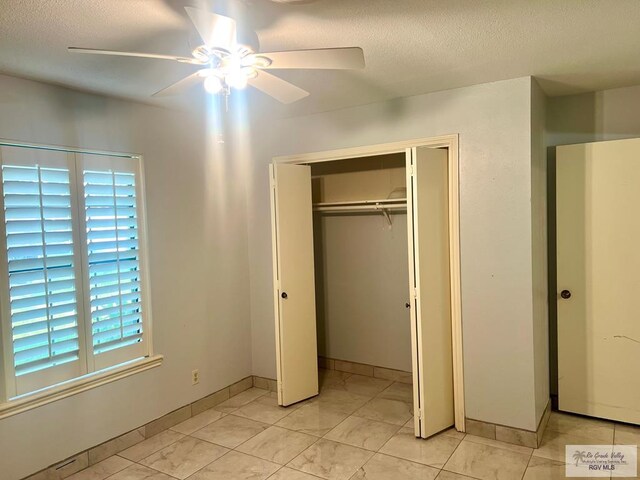 501 W Palm Valley Dr, Harlingen, TX 78552 - unfurnished bedroom featuring a textured ceiling, a closet, baseboards, and ceiling fan